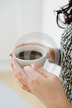 Close up of female hands with a mug of coffee.