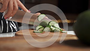 Close-up female cook hands chopping pepper for salad on a wooden board in the kitchen. Healthy eating.