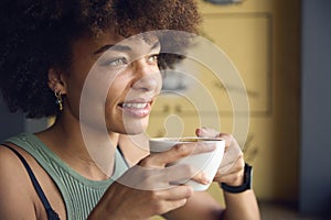 Close Up Of Female Customer In Window Of Cafe Drinking Coffee
