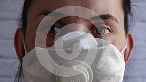 Close up of a female doctor blinking her eyes. Macro view, woman face in medical protective mask. Be safe. Portrait of a young wom