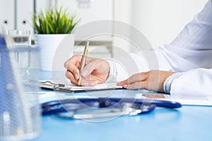 Close-up of female doctor filling medical form