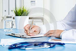 Close-up of female doctor filling medical form