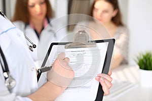 Close-up of a female doctor while filling up medical history record