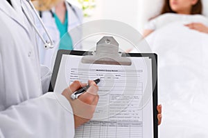 Close-up of a female doctor while filling up medical history record