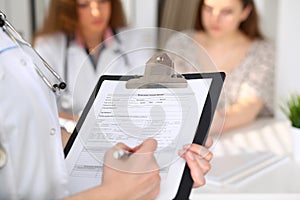 Close-up of a female doctor while filling up medical history record