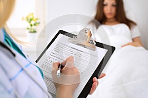 Close-up of a female doctor while filling up medical history record