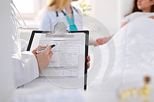 Close-up of a female doctor while filling up medical history record