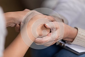 Close up of female doctor hold patient hands showing support