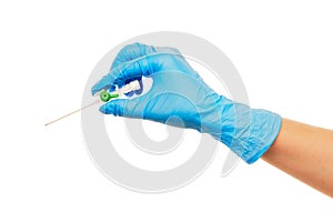 Close up of female doctor's hand in blue sterilized surgical glove with green plastic catheter against white