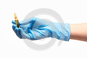 Close up of female doctor's hand in blue sterilized surgical glove holding transparent brown glass ampoule with a drug