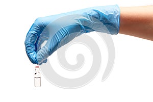 Close up of female doctor's hand in blue sterilized surgical glove holding transparent white glass ampoule with a drug