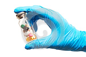 Close up of female doctor's hand in blue sterilized surgical glove holding transparent white glass ampoule filled with different t