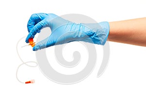 Close up of female doctor's hand in blue sterilized surgical glove with orange plastic catheter against white