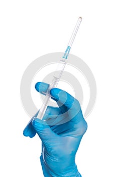 Close up of female doctor`s hand in blue sterilized surgical glove with plastic medical syringe white background