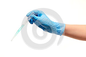 Close up of female doctor's hand in blue sterilized surgical glove with white plastic medical dropper filled with blue drug