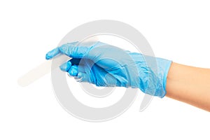 Close up of female doctor's hand in blue sterilized surgical glove with white plastic medical spatula against white