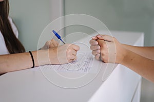 Close up of female and doctor& x27;s hand on table during writes the recipe