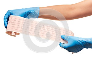 Close up of female doctor's hands in blue sterilized surgical gloves with ECG results on paper