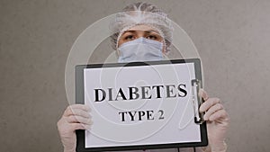 Close-up of female doctor in a uniform holding a sign that says TYPE 2 DIABETES.