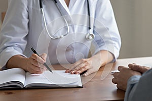 Close up of female doctor write prescription in journal