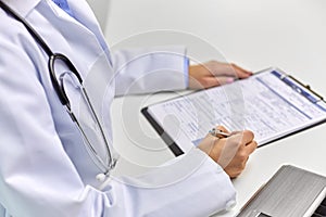 Close up of female doctor writing medical report