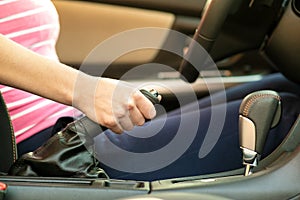 Close up of female driver hand holding hand brake in a car
