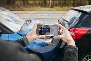 Close Up Of Female Driver Taking Photos Of Road Traffic Accident On Mobile Phone For Insurance Claim