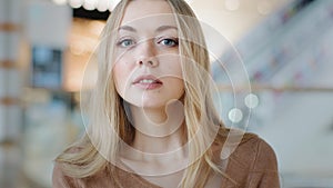 Close-up female face indoors portrait blond 20s girl millennial woman lady confused female looking at camera with