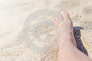 Close up of female feet on a hot sand on the beach