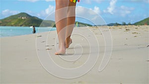 Close up female feet walking barefoot on the beach. Slow Motion.