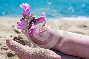 Close up of female feet on white sand beach