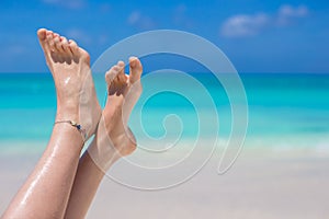 Close up of female feet on white sandy beach