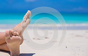 Close up of female feet on white sandy beach