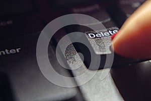 Close up of female finger pressing the delete key.