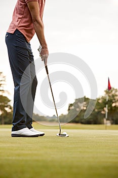 Close Up Of Female Golfer Putting Ball On Green