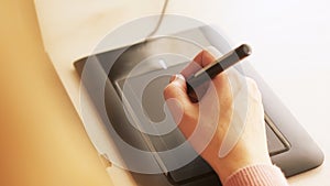 Close-up of female graphic designer`s hand using interactive pen display, digital drawing tablet and pen on a computer