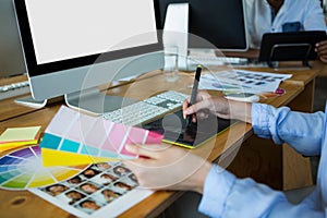 Close-up of female graphic designer using graphics tablet at desk