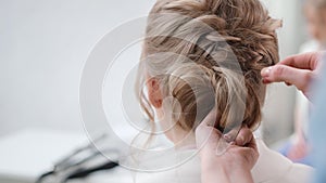 Close up female hairdresser hands fixing plaiting hairstyle using barrette. 4k Dragon RED camera