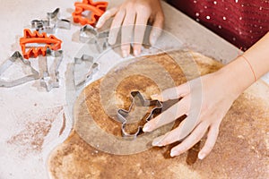 Close-up of female hand cutting dough with cookie cutter