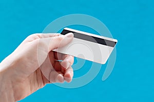 Close up of a female hand holding a blank white business card with a magnetic stripe. Business idea, electronic money