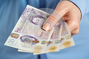 Close up of female hand holding British pounds currency.