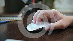 Close-up of a female hand holding a computer mouse.