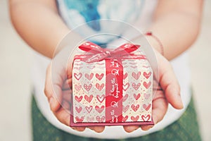 Close up female hand holding a small gift heart pattern. With re