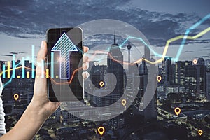 Close up of female hand holding smartphone with abstract glowing growth chart and arrow on blurry city background with location