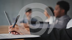 Close-up female hand holds pen unrecognizable girl makes notes on sheet of paper sign document employee write financial