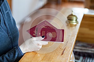 Female hand holds russian passport at wooden reception desk