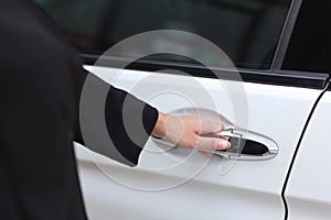 Close up female hand opening car or automobile door