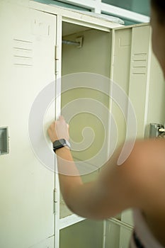 Close-up. A female hand opens a metal cabinet with her things in a yoga center.