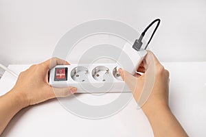 Close-up of hand plugging a plug into a multiple socket