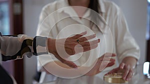 Close-up female hand with ring with gemstone and unrecognizable shop assistant gesturing at background. Unrecognizable